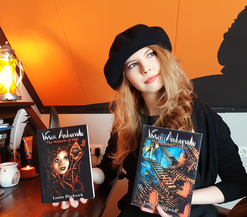 Louise Blackwick holding 2 Vivian Amberville books